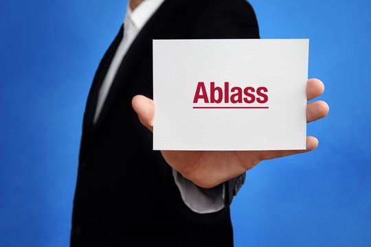 Ablass. Anwalt h&auml;lt Karte in der Hand. Beschriftung auf Schild zeigt Begriff. Hintergrund blau. Recht, Gesetz, Rechtsprechung