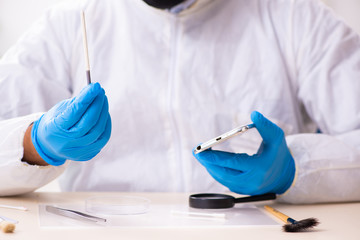 Male expert criminologist working in the lab for evidence