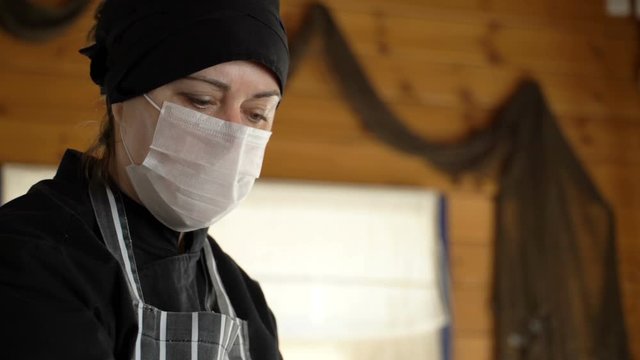 Restaurant Worker Wearing Medical Mask And Gloves Collecting A Food Box Take Away. Food Delivery Services During Coronavirus Pandemic And Social Distancing. Online Contactless Food Shopping.