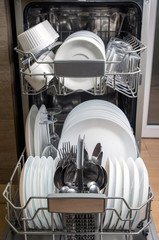 child hand puts detergent in the dishwasher, vertical position