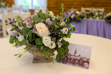 Wedding decor. A beautifully decorated festive table of fresh flowers in an antique vase, in purple shades