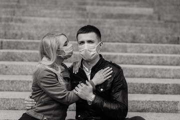 Young couple in love in protective medical mask on face outdoor at street. Environmental pollution concept. Guy and girl in virus protection