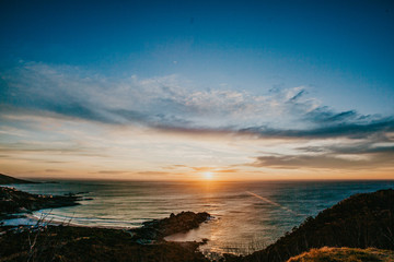 A beautiful sunset over the ocean from the top of the hill in the pristine and quaint town of Llandudno in Cape Town
