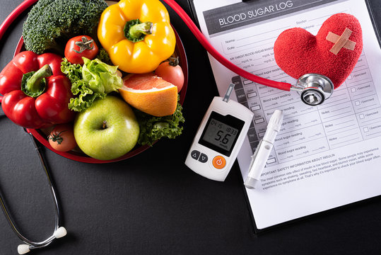 World diabetes day and healthcare concept. Patient's blood sugar control, diabetic measurement, and healthy food eating nutrition with red heart on black background.