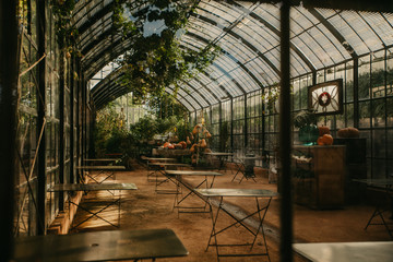 A greenhouse set up with tables at sunset. 
