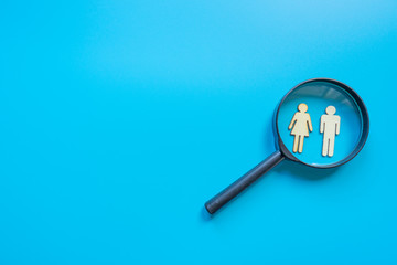 Employee search HR concept - magnifier with abstract employee on a blue background. Close up.