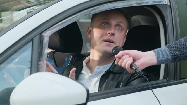 Journalist Interviews of discontented, nervous, aggressive driver, close-up. A journalist interviews a driver Protestant in a car. Protest against rising fuel prices, high transport tax