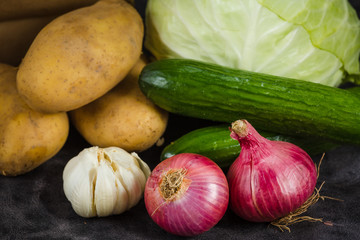 vegetables and fruits potato cabbage banana melon grape cucumbers onion garlic orange apples pear a dark background