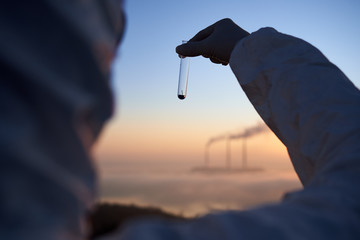Cropped close-up snapshot of a scientist standing with his back to the camera, with his face to a...