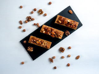 rectangular chocolate brownies with nuts on a black board