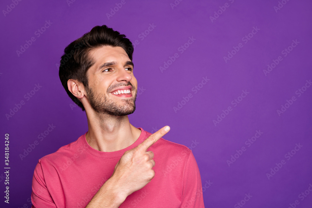 Poster closeup photo of attractive guy good mood directing finger side empty space showing cool offer shopp