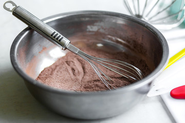 Woman professional pastry chef prepares chocolate dough.