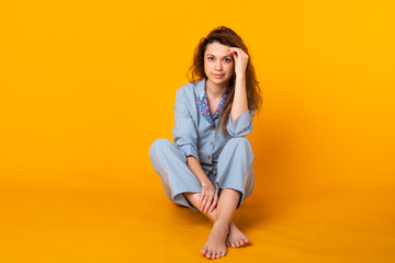 Close up young woman in blue home wear. Isolated on yellow background. Pajama concept.