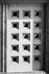 The white stone's door.
Black and white picture of a massive stone door with square patterns.