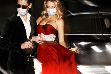 Couple in face mask near the car.
