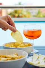 young man taking a potato chip from a bowl