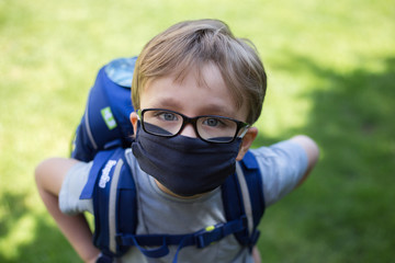 Junge mit Schulranzen und Maske