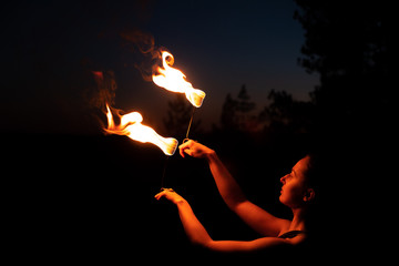 girl at night turns a fire show