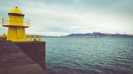 Yellow lighthouse at the entrance to Old Harbour Reykjavik