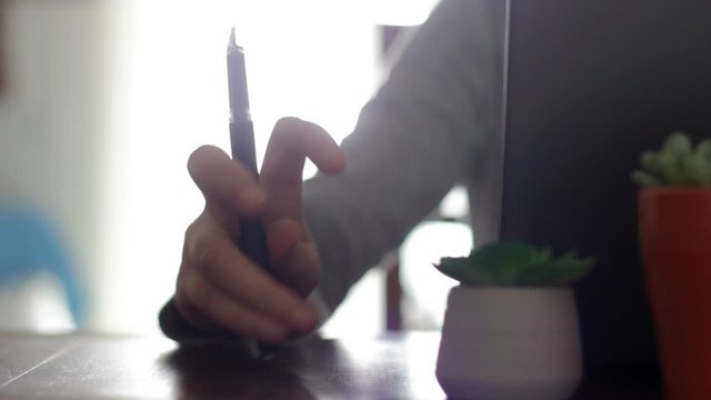 Nervous woman tapping with pen on table