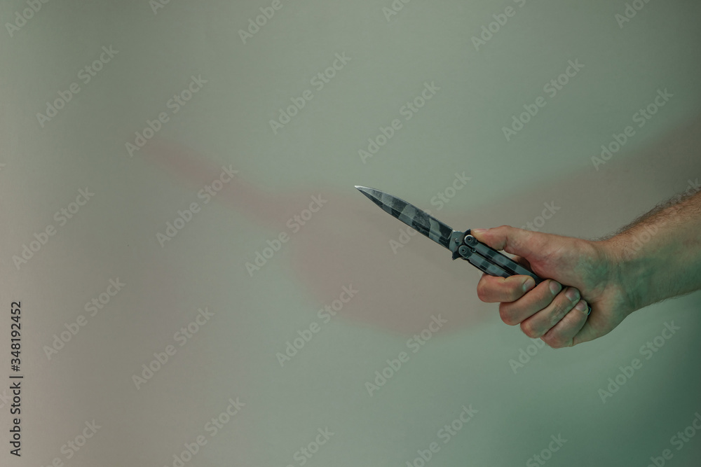 Aufkleber hand holding old butterfly knife in the color light. beautiful old minimal in neon light. minimalism