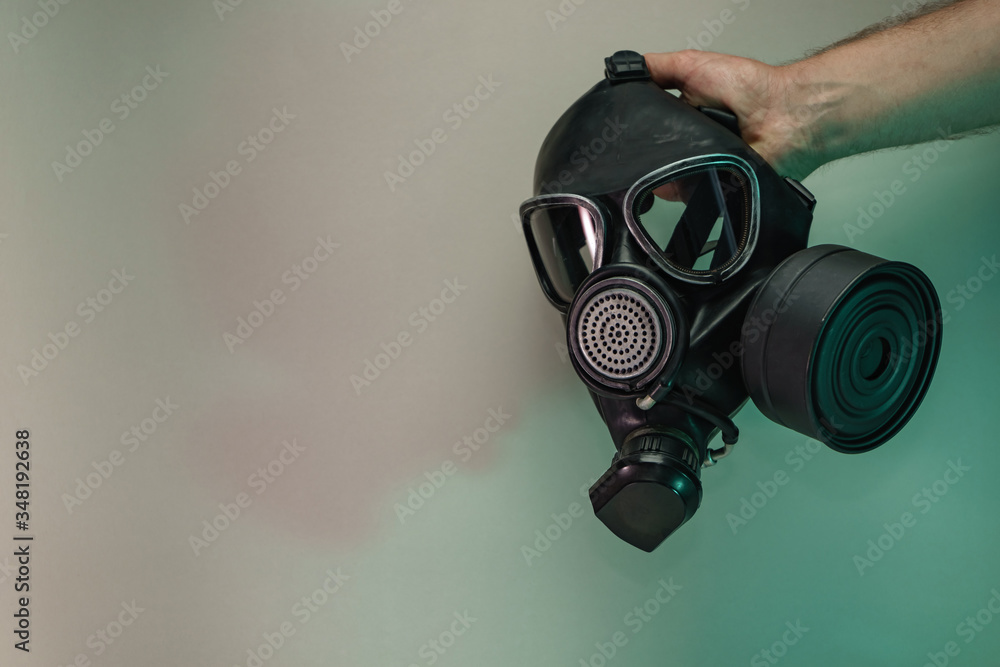 Poster Hand hold black old gas mask in the color light. Beautiful old minimal in neon light. Minimalism retro style concept. Background pattern for design.