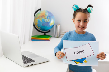 Happy little child child girl has idea. Online education for small kids. Kid studding on laptop