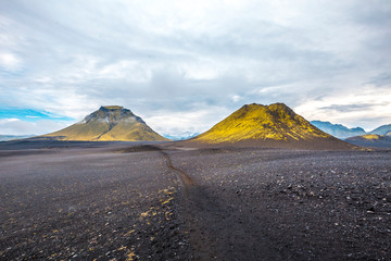 Volcanic ash and two green mountains in the background on the 54 km trek from Landmannalaugar,...