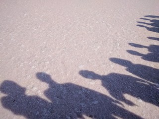 Friends' shadow on crystal sand