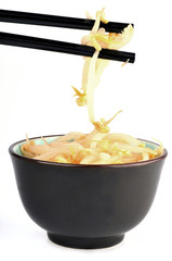 Bol de germes de soja avec des baguettes chinoises en gros plan sur fond blanc