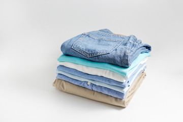 Stack of colorful perfectly folded clothing items. Pile of different pastel color shirts, sweaters...