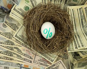 background from notes of us dollars, nest with egg, percent icon on an egg, receiving dividends