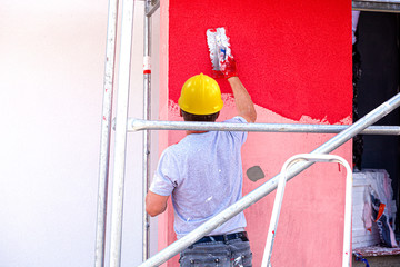 Construction workers plaster the facade of the house. Application Of Facade Plaster.