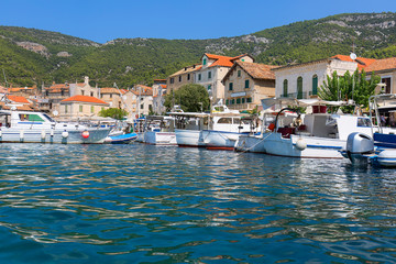 View on port on Adriatic Sea, moored boats and old buildings, island Vis, Komiza, Croatia