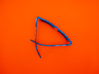 Fashion summer concept blue sunglasses on an orange background.