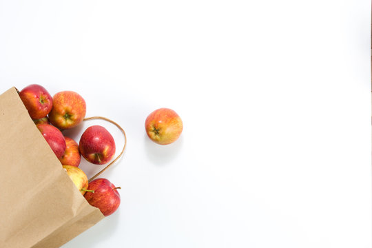 Apples And Pears In A Paper Bag Of Craft Paper On White Background. Free Space For Your Text. Top View