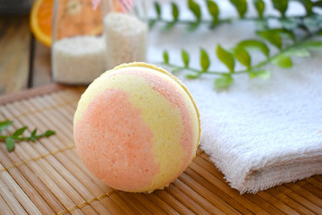 Close up aromatherapy spa design with bath bomb and towel on wooden background. Fresh citrus scented cosmetic.. Still life concept for summer resort dayspa treatment.