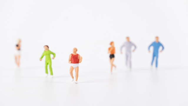 miniature people running on white background