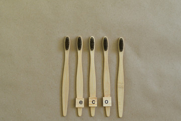 Eco-friendly bamboo toothbrush.Wooden letter ECO . Paper background. Zero waste, life without plastic. Ecology concept. Save the world.