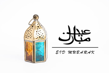 Eid Mubarak greetings in Arabic with Arabic lantern on white background