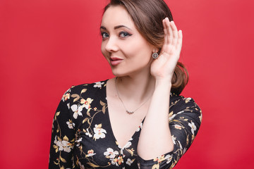 Portrait of a beautiful girl on a red background, which shows different emotions. Human face expression, emotions, feeling attitude reaction