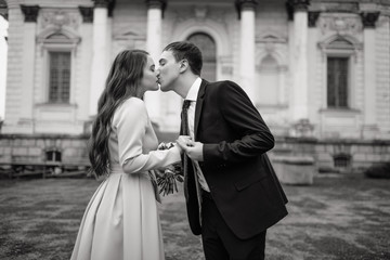 Happy bride and groom kiss on a background old cathedral, wedding concept.