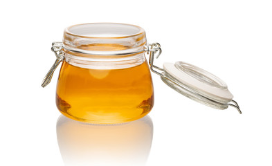 open glass jar with honey on a white background