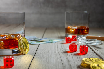 Two Glasses With Whiskey, Dice and Bitcoins on a Rustic Wooden Table