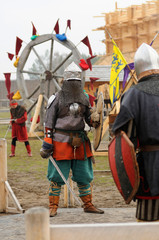 Reenactors dressed in armor of Old Russian footmen reconstructing swords fight