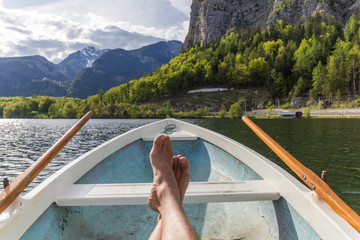 bare feet of a man in a boat sailing on a lake in austrian tyrol