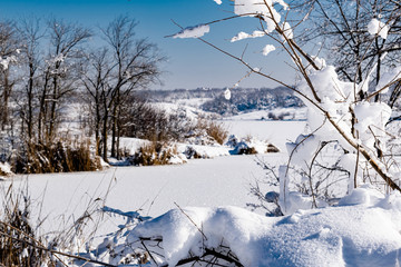 Spacious snow landscape. River and hills in Russia, white winter on the terrain, a lot of fluffy snow and ice under a beautiful blue sky. Rostov region, town of Shakhty, the river Grushevka 