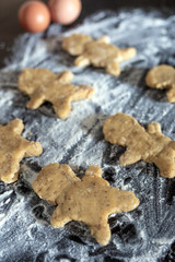 Person baking Gingerbread man cookies, Person hands in dough with flower in cozy kitchen