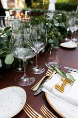 in backyard of villa in Tuscany there is banquet wooden table decorated with cotton and eucalyptus compositions.