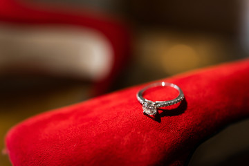 Wedding rings on red shoes of the bride.